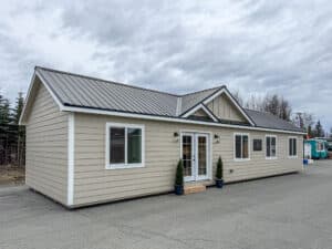 Side view of the Bighorn Modular by Northwood Buildings featuring a gable roof, metal roofing, multiple windows, and French doors.